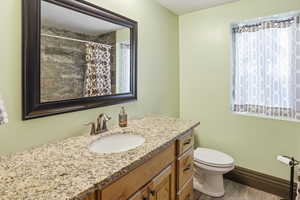 Bathroom featuring vanity, curtained shower, and light wood-style floors