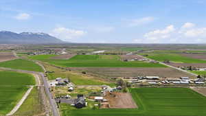 Overview of rural landscape featuring large plots for crops and a mountainous background