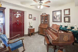 Home office with light carpet and a ceiling fan