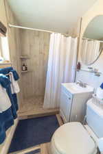 Bathroom featuring a shower stall, vanity, and light wood finished floors