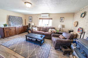 Living area with light wood finished floors and a textured ceiling