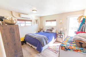 Bedroom with wood finished floors, access to exterior, and multiple windows
