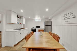 Kitchen with light countertops, stainless steel appliances, white cabinetry, recessed lighting, and open shelves