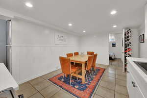 Dining area featuring wainscoting, recessed lighting, wood walls, and light tile patterned floors