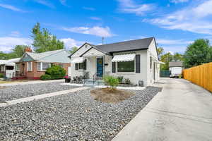 View of front of home with brick siding, driveway, board and batten siding, and roof with shingles