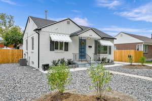 View of front of house with brick siding, board and batten siding, roof with shingles, and a porch