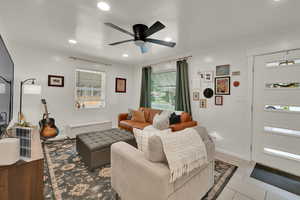 Living area with light tile patterned flooring, ceiling fan, and recessed lighting