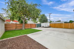 Fenced backyard featuring a shed