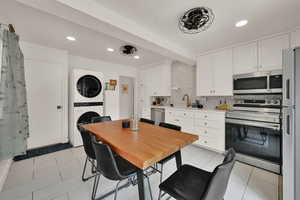 Dining area with stacked washer and clothes dryer, recessed lighting, and light tile patterned floors
