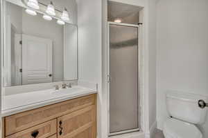 Full bath featuring a stall shower and vanity