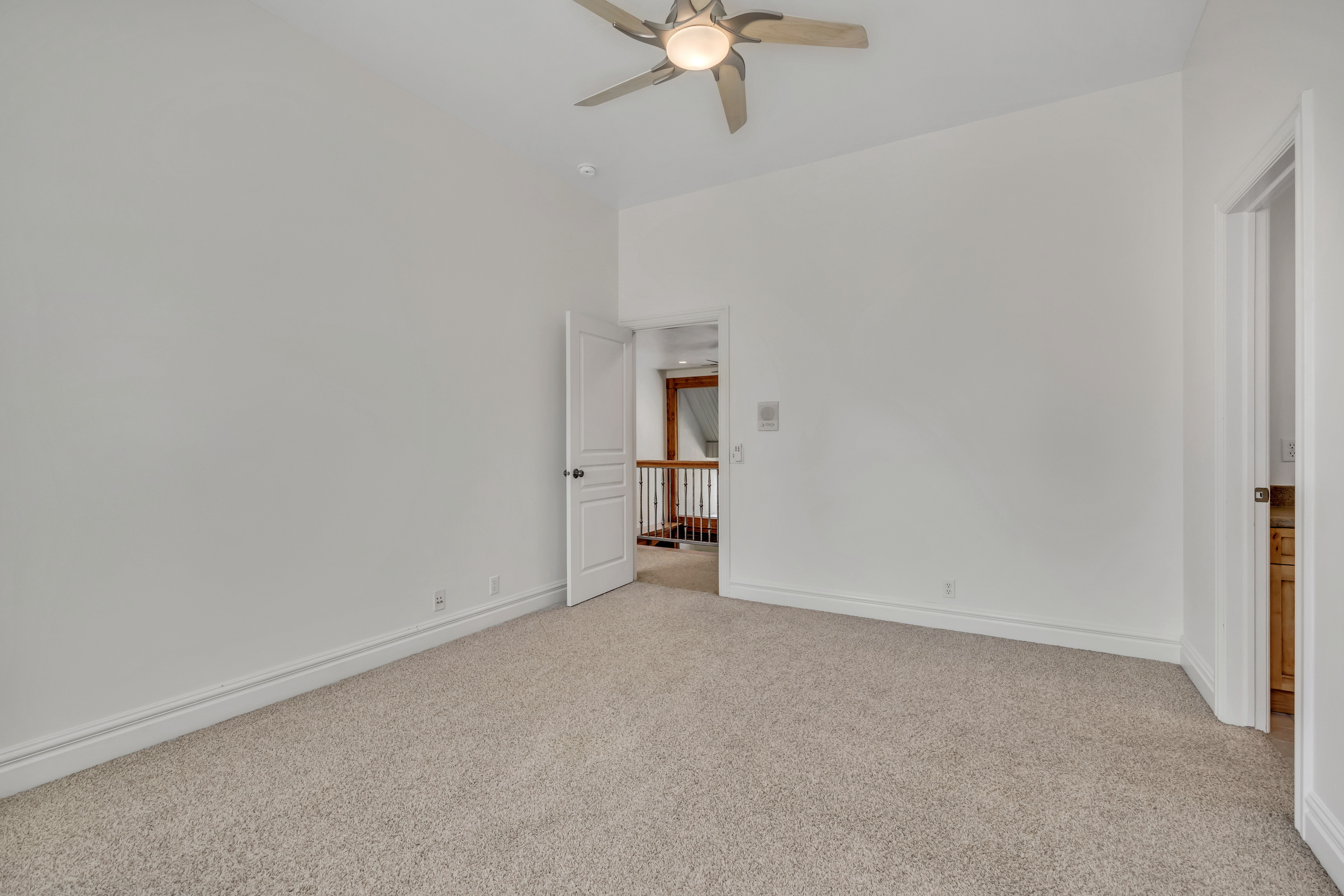 Unfurnished bedroom with light colored carpet and a ceiling fan