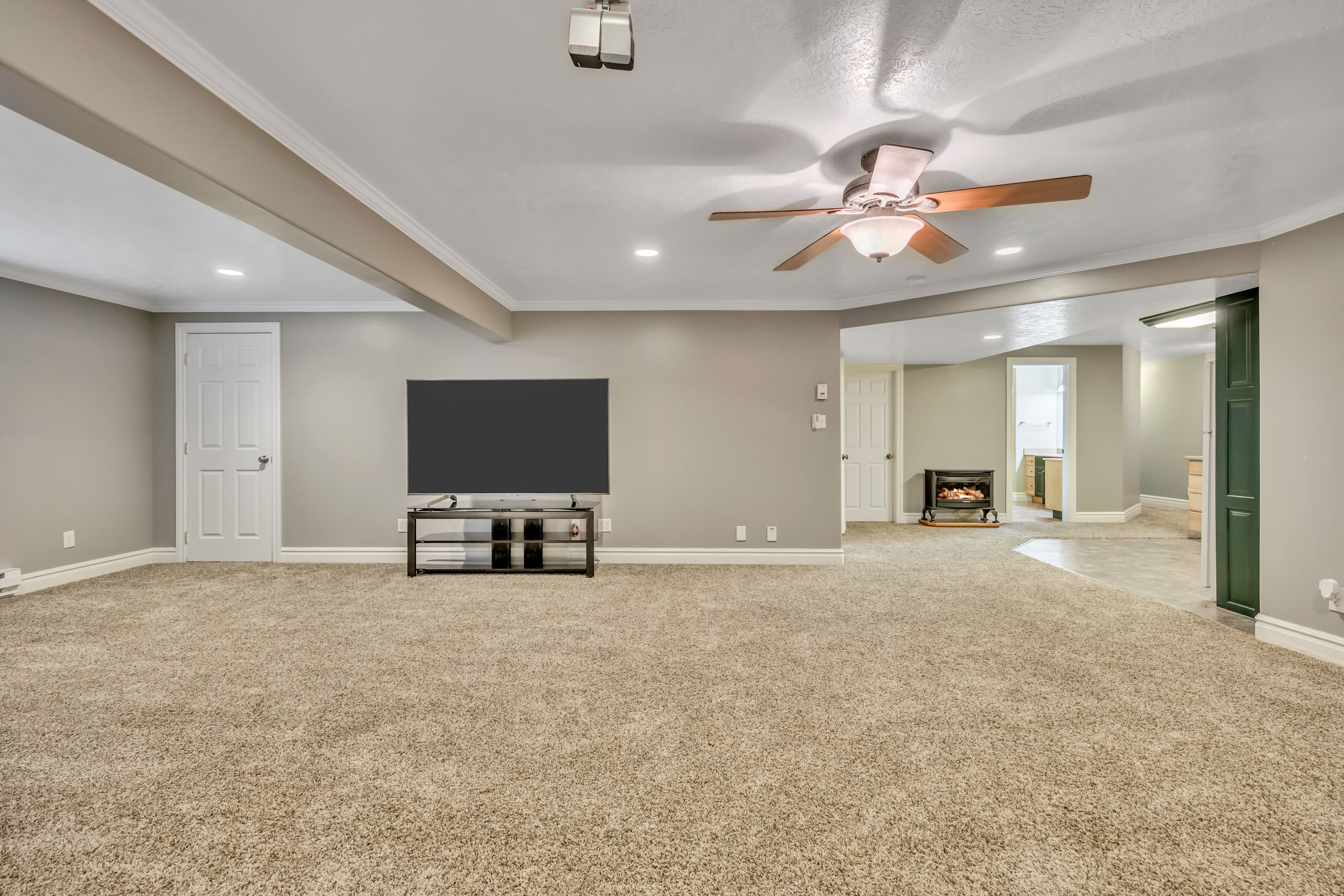 Unfurnished living room with a ceiling fan, crown molding, light colored carpet, and recessed lighting