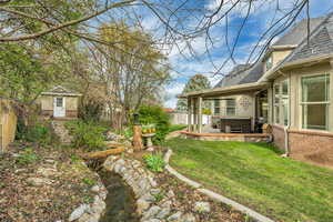 Fenced backyard with a patio area, a hot tub, and a storage unit