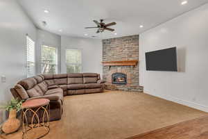 Living area featuring a ceiling fan, a fireplace, recessed lighting, wood finished floors, and carpet flooring