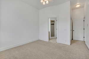 Unfurnished bedroom featuring light colored carpet and ceiling fan