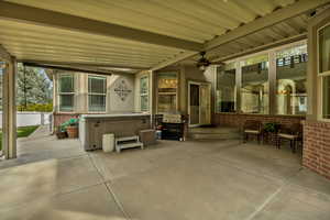 View of patio with a hot tub, a ceiling fan, and area for grilling