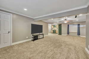 Unfurnished living room with light carpet, recessed lighting, baseboard heating, crown molding, and ceiling fan