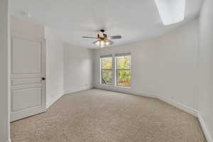 Empty room featuring light colored carpet and ceiling fan