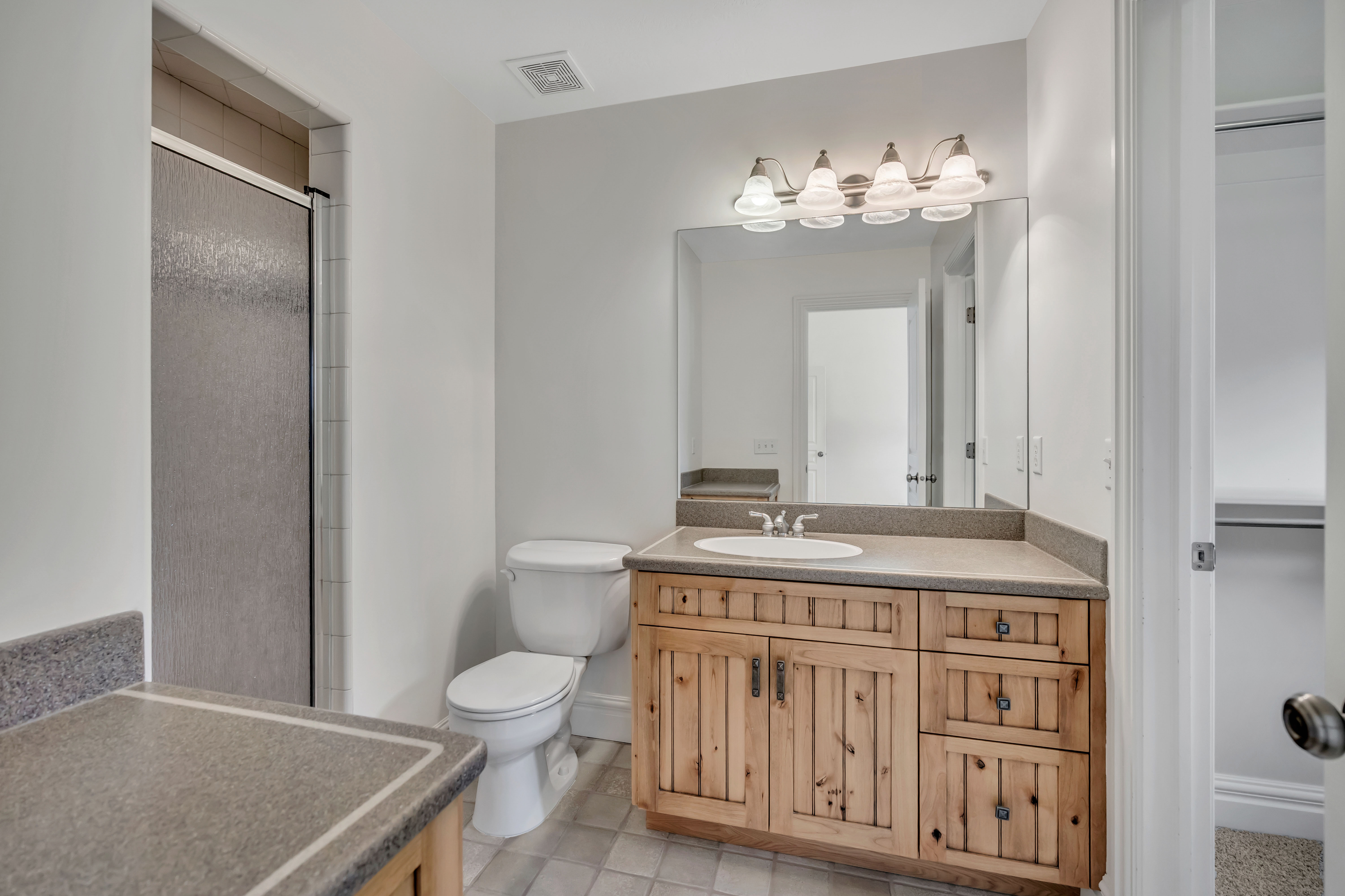 Full bathroom with vanity, a stall shower, and light tile patterned flooring