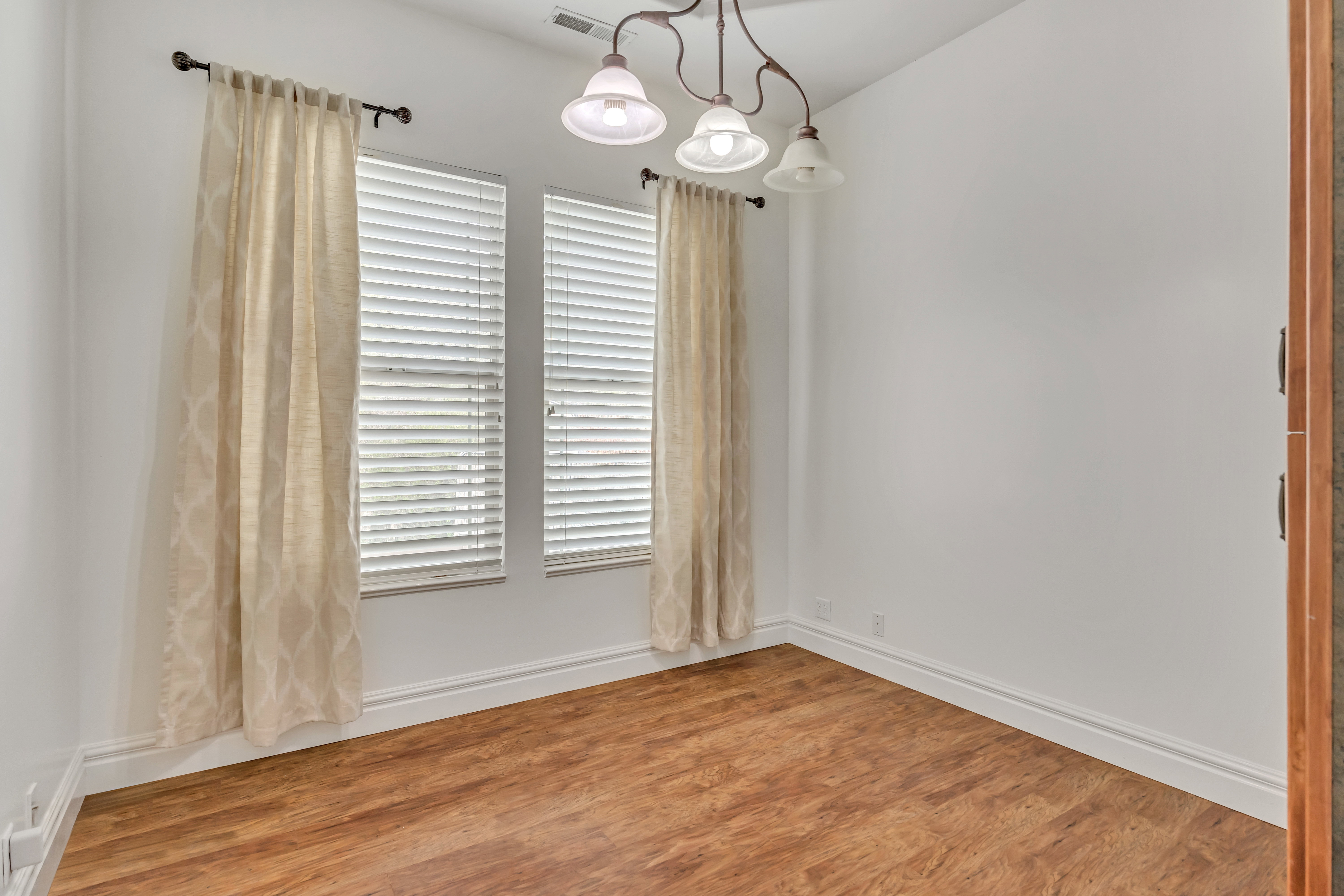 Unfurnished room featuring light wood finished floors and baseboards