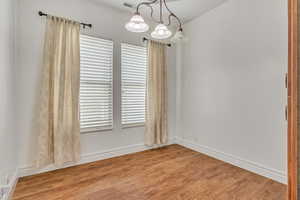 Unfurnished room featuring light wood finished floors and baseboards