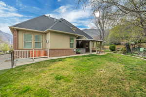 Rear view of property with a fenced backyard, brick siding, a patio, a shingled roof, and stucco siding