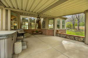 Unfurnished sunroom with a patio and ceiling fan