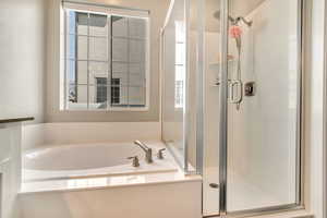 Full bathroom featuring a stall shower and a bath