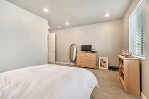 Carpeted bedroom featuring recessed lighting and a textured ceiling