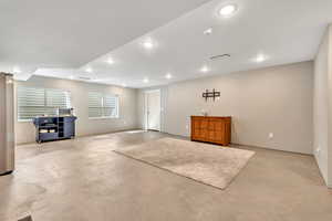 Basement with freestanding refrigerator and recessed lighting
