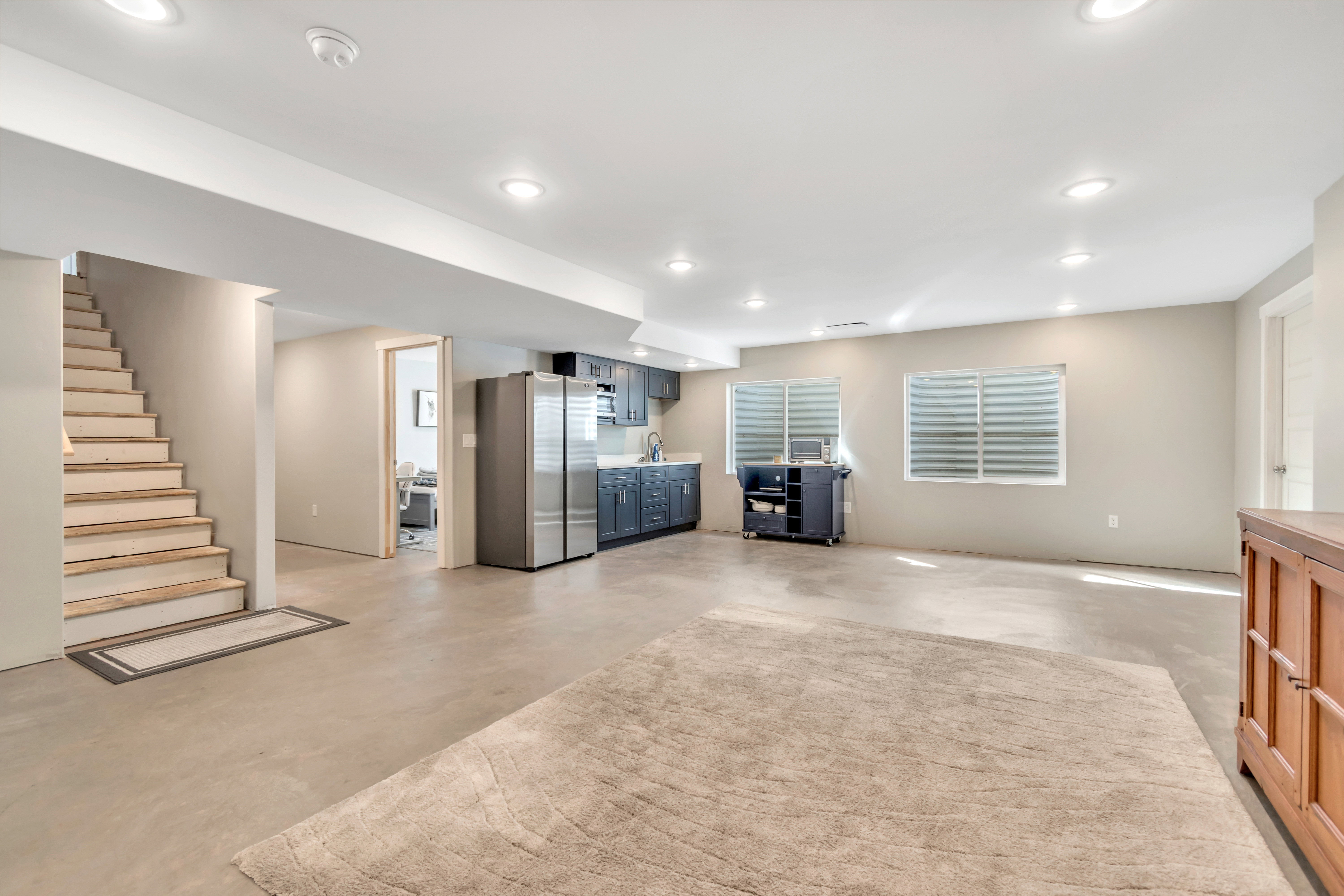 Below grade area featuring freestanding refrigerator and recessed lighting
