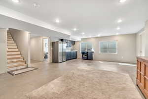 Below grade area featuring freestanding refrigerator and recessed lighting