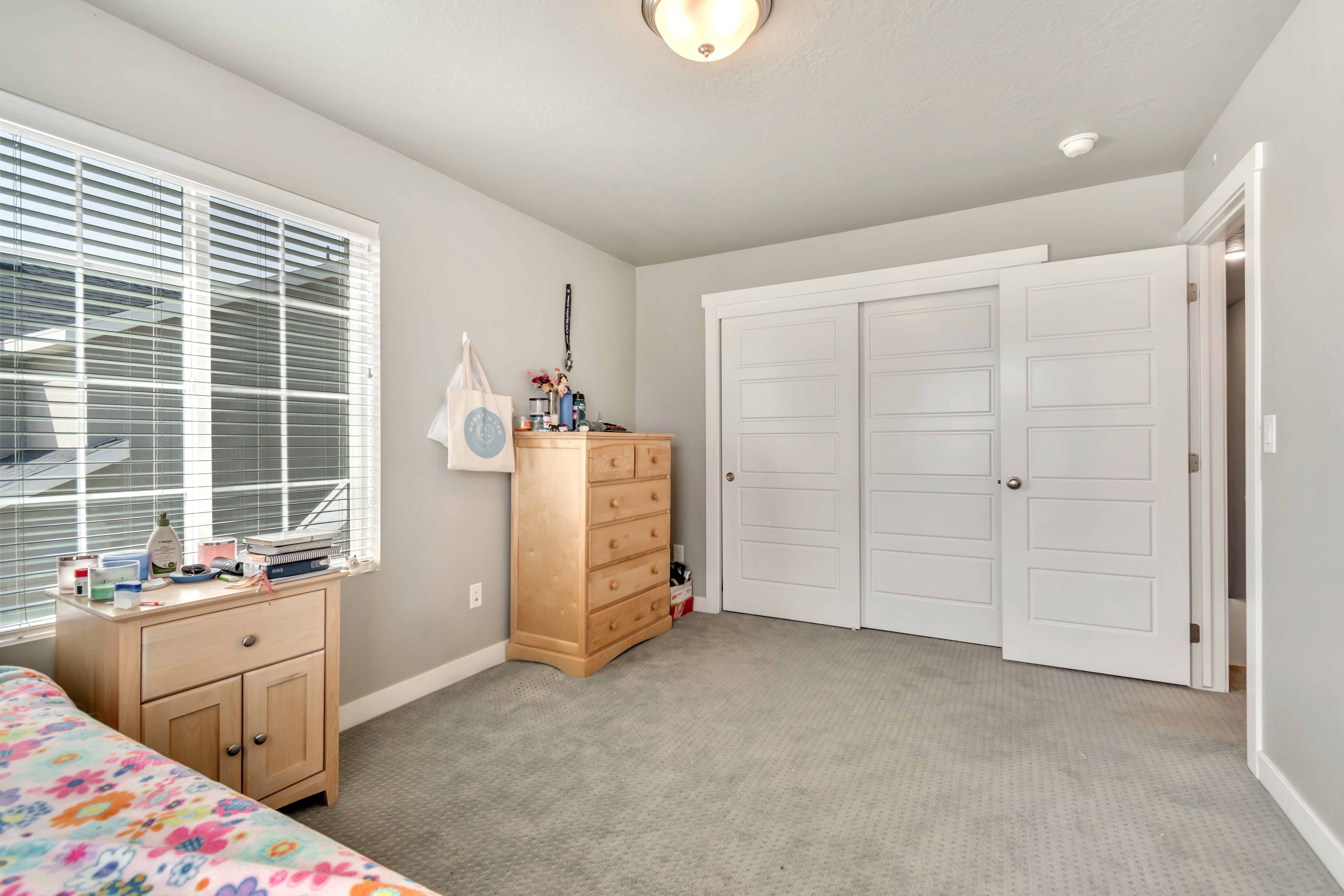 Bedroom with light colored carpet and a closet