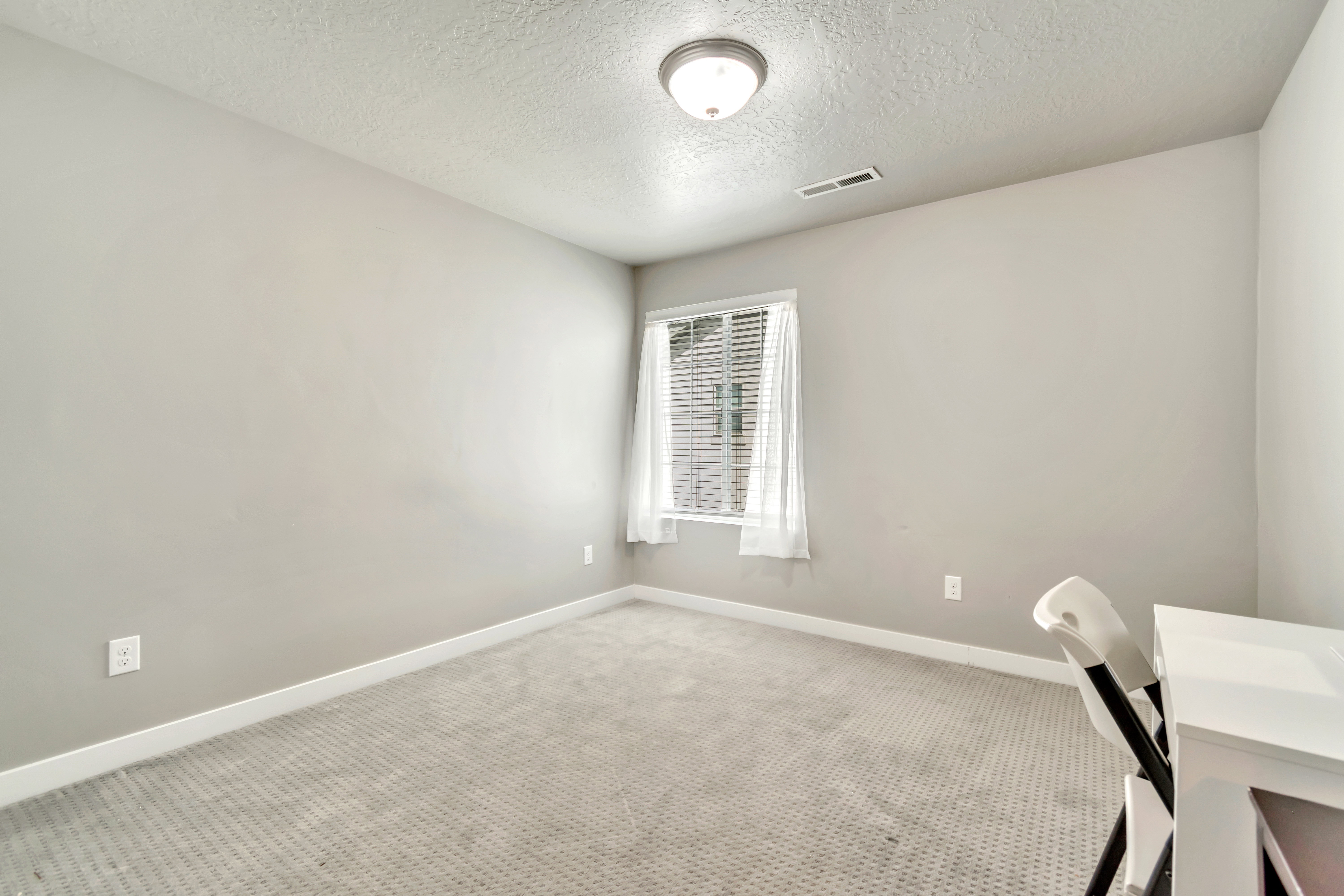 Unfurnished office featuring a textured ceiling and carpet floors