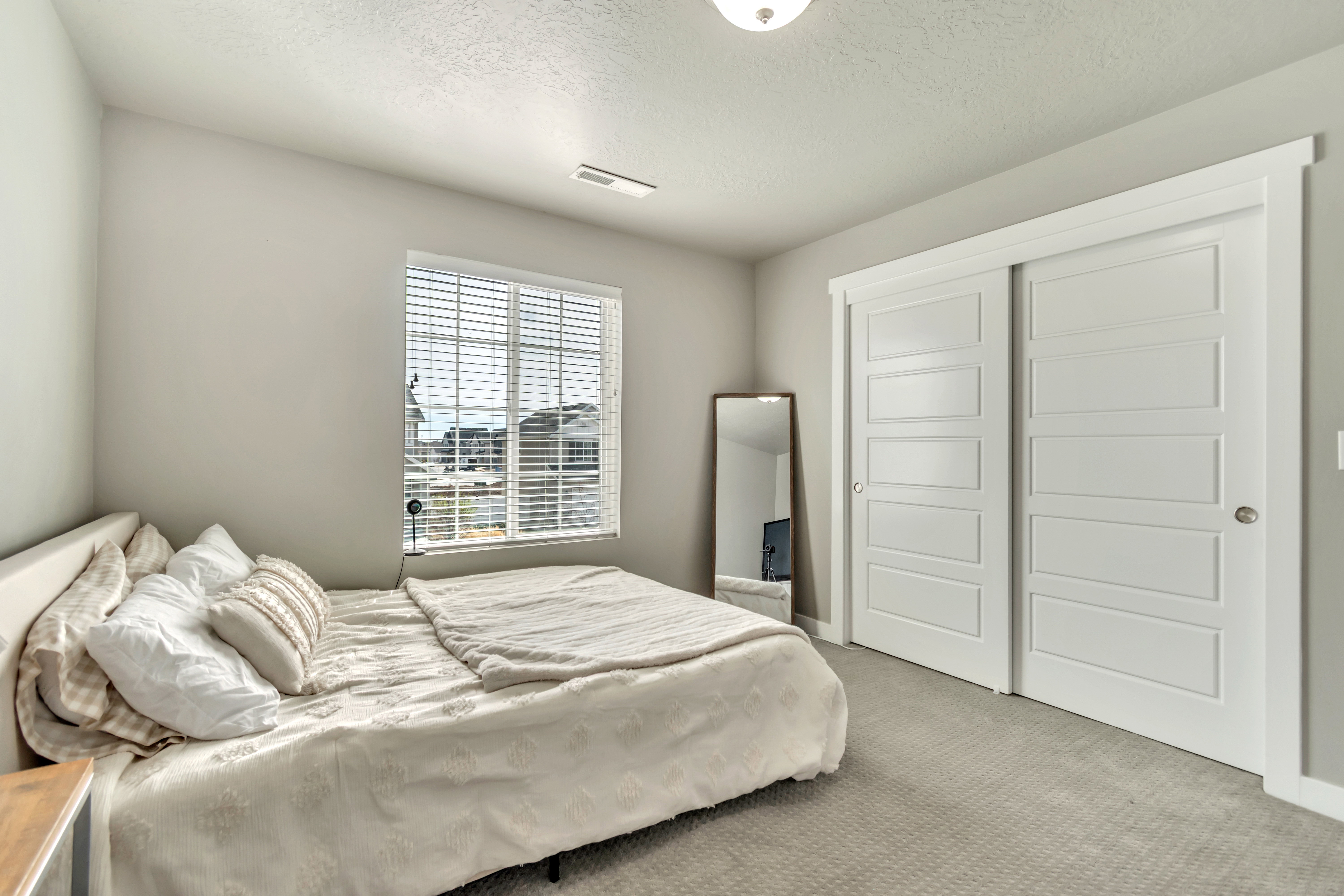 Bedroom with carpet floors, a textured ceiling, and a closet