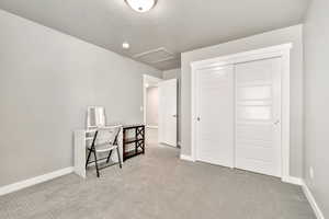 Bedroom with light colored carpet, a closet, and a textured ceiling