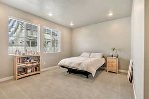 Bedroom featuring recessed lighting, light colored carpet, and a textured ceiling