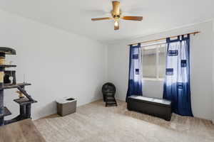 Miscellaneous room featuring a ceiling fan and light carpet