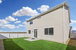 Rear view of house featuring a fenced backyard, a putting green, a patio area, a gate, and stucco siding