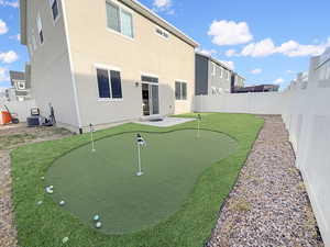 Fully fenced backyard is designed for easy living with maintenance-free xeriscaping, high-end turf, and even a built-in putting green