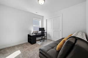 Office space with light colored carpet and baseboards