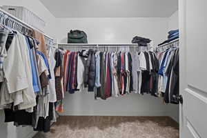 Walk in closet with light carpet