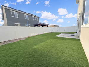 Fully fenced backyard is designed for easy living with maintenance-free xeriscaping, high-end turf, and even a built-in putting green