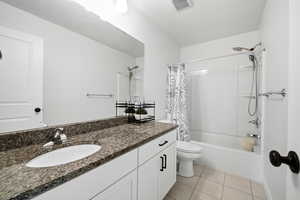 Full bath featuring vanity, shower / tub combo, and light tile patterned floors