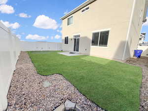 Fully fenced backyard is designed for easy living with maintenance-free xeriscaping, high-end turf, and even a built-in putting green