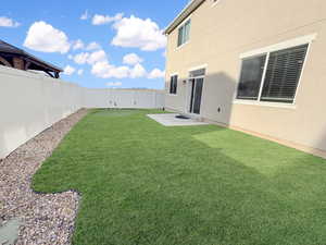 Fully fenced backyard is designed for easy living with maintenance-free xeriscaping, high-end turf, and even a built-in putting green