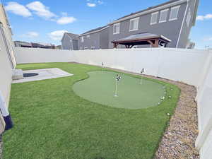 Fully fenced backyard is designed for easy living with maintenance-free xeriscaping, high-end turf, and even a built-in putting green