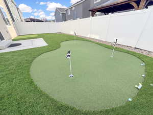 Fully fenced backyard is designed for easy living with maintenance-free xeriscaping, high-end turf, and even a built-in putting green