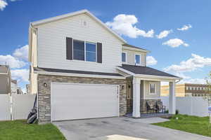 Craftsman inspired home featuring stone siding, an attached garage, a porch, driveway, and roof with shingles