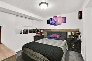 Bedroom with a textured ceiling and carpet